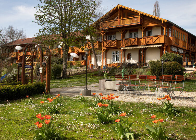 Ein Hotel mit gepflegten Blumenbeeten im Eingangsbereich - Hotel Quellenhof
