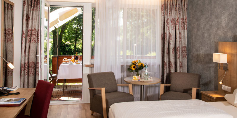 Ein elegantes Doppelzimmer Komfort Südlage mit einem Arbeitsbereich im Hotel Quellenhof.