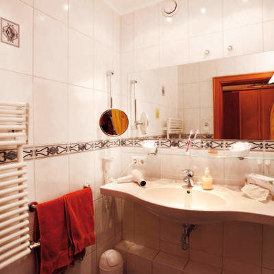 Ein schickes Badezimmer im Hotel Quellenhof großem Waschbecken und weiterer moderner Einrichtung.