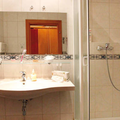 Ein modernes helles Badezimmer mit Dusche und neuer Einrichtung im Hotel Quellenhof in Bad Birnbach.