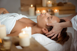 Eine Frau ruht sich auf einer Massageliege aus und genießt eine Massage im Wellnessbereich des Hotel Quellenhof.