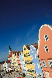 Eine Häuserreihe in der Innenstadt in Bad Birnbach mit blauen Himmel im Hintergrund.